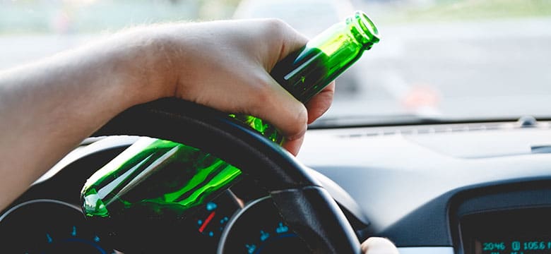 Person-Driving-Car-with-Bottle-of-Beer
